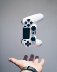 White joystick floating onto the hands of a person wearing a black-strapped watch